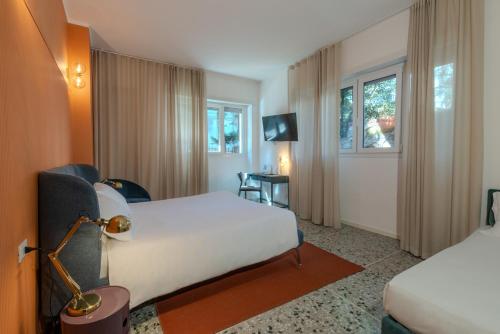 a hotel room with two beds and a television at Marcello's Como Lake in Como