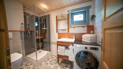 a bathroom with a shower and a washing machine at Vakantiewoning Vrijburg in Schagerbrug