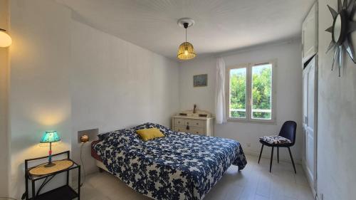 a bedroom with a bed and two tables and a window at La Santoline - Provençal break with pool in Le Thor