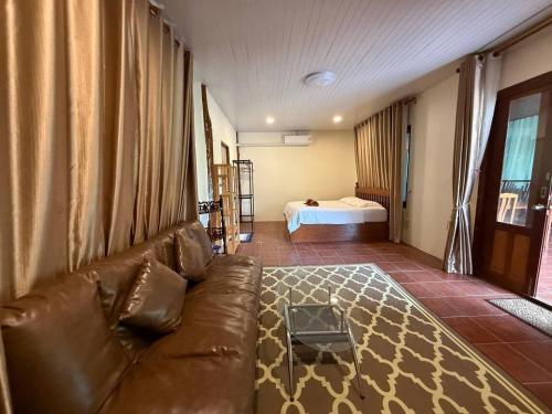 a living room with a couch and a bed at Buddha Raksa in Thong Nai Pan Yai