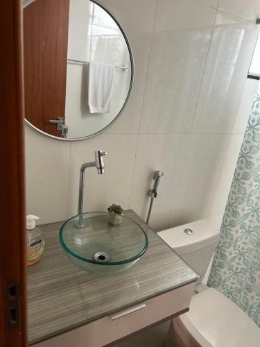 a bathroom with a sink with a mirror and a toilet at Chalé 3 vista para montanha in Itatiaia
