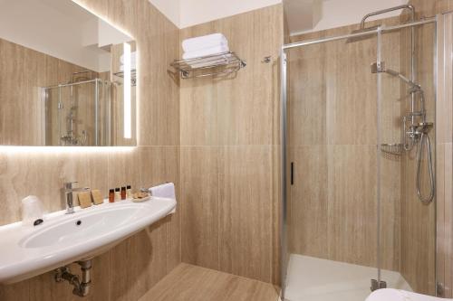 a bathroom with a sink and a shower at Hotel Gallia & Resort in Lido di Jesolo