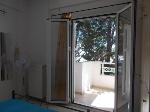 a sliding glass door in a room with a window at Διαμέρισμα τριών ατόμων in Filiatra