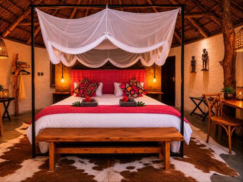 a bedroom with a large bed with a canopy at Addo African Home in Addo