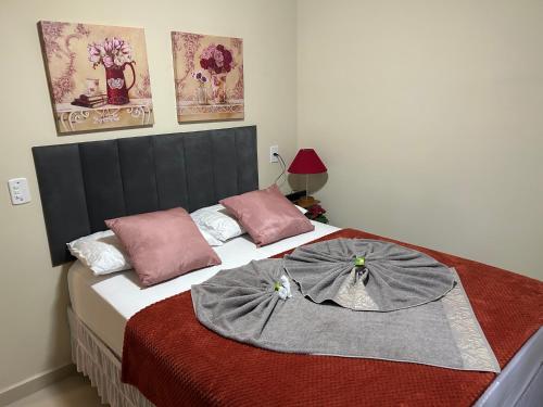 a bedroom with a bed with two pillows on it at Chalé 3 vista para montanha in Itatiaia
