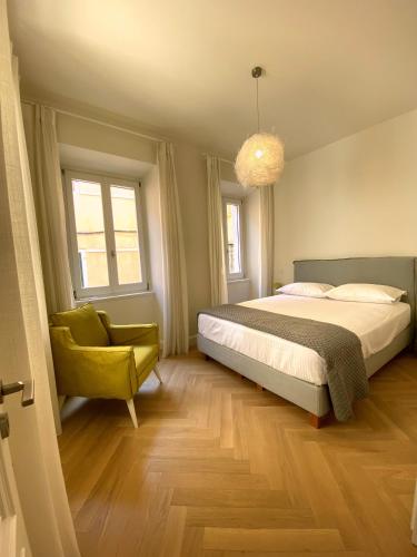 a bedroom with a bed and a green chair at Psaradika Apartment Modern Comfort in Corfu Old Town in Corfu