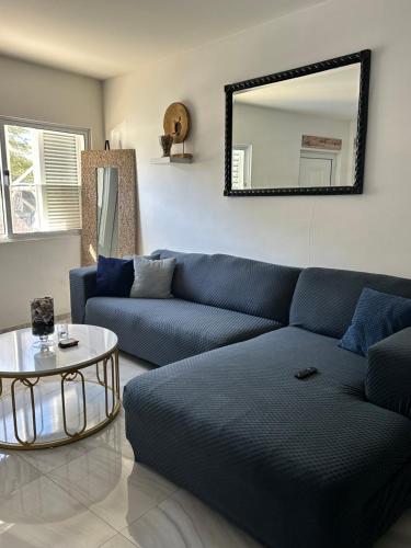 a living room with a blue couch and a mirror at Coraçon di Mindel Apartment in Mindelo