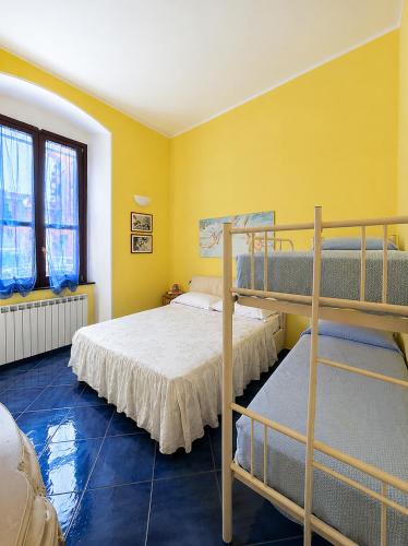 a bedroom with two bunk beds and a yellow wall at Casa con Cortile, Barbecue e Parcheggio Privato in Sestri Levante