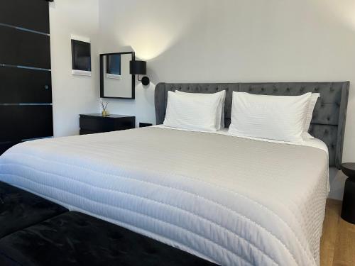 a bedroom with a large bed with white sheets at Apollonio Suites in Korinthos