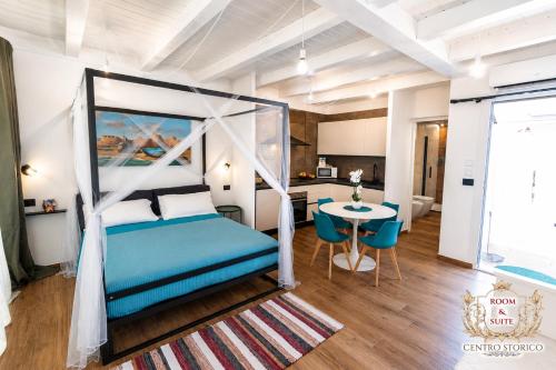 a bedroom with a blue bed and a table at Centro Storico Rooms & Suites in Manfredonia