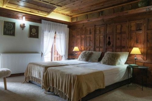 a bedroom with a large bed with wooden walls at Конак Буката in Bukata