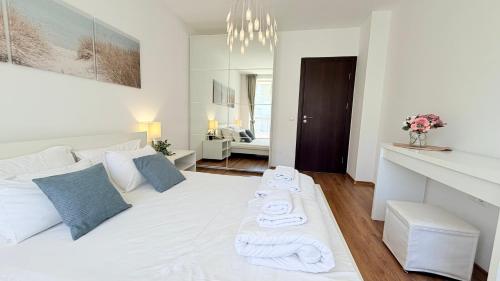 a bedroom with a white bed with towels on it at Бяла Виста Клиф - Byala Vista Cliff in Byala