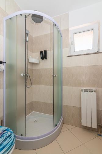 a shower with a glass door in a bathroom at Apartman Hana u blizini ronilačkog kluba i Kostrenskih plaža in Kostrena