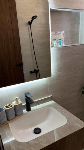 a bathroom with a white sink and a shower at شقة انيقة بغرفة وصالة in Buraydah