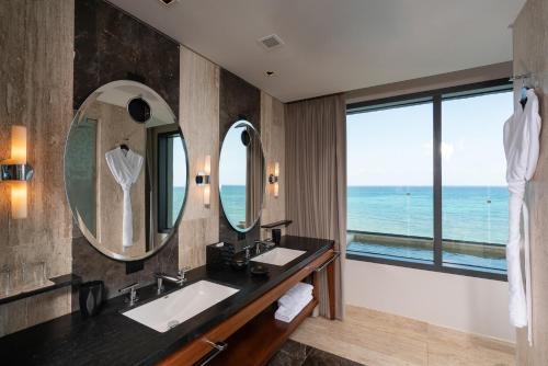 a bathroom with two sinks and a large mirror at Hyatt Centric Playa del Carmen - Downtown House & Beach House in Playa del Carmen