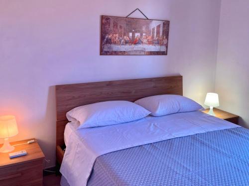 a bedroom with a bed with blue sheets and two lamps at Casetta IV Vico- Chianalea in Scilla