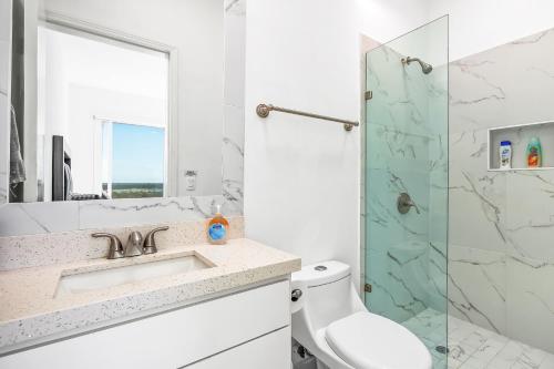 a white bathroom with a sink and a shower at Dog-Friendly Home with Heated Pool, Hot Tub, Partial Ocean Views & Balcony in Rosarito