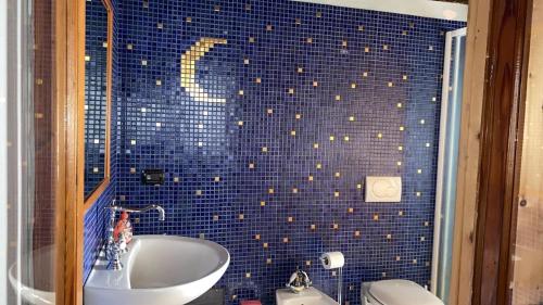 a blue tiled bathroom with a sink and a toilet at RIVER resort in Varallo