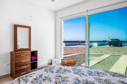 a bedroom with a bed and a large glass window at Dog-friendly Villa with Heated Pool, Hot Tub, Streaming, Partial Ocean Views in Rosarito