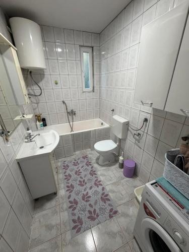 a bathroom with a tub and a toilet and a sink at Home Two Brothers in Bar