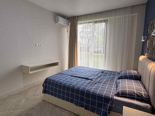 a bedroom with a blue bed in front of a window at Дом Sand in Ureki