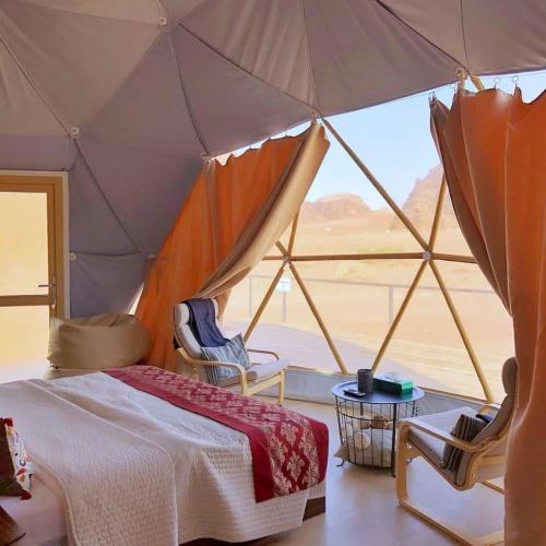 a bedroom with a tent with a view of the desert at Ain Rum Luxury Camp in Wadi Rum