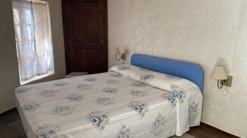 a bed in a bedroom with a blue and white bedspread at RIVER resort in Varallo