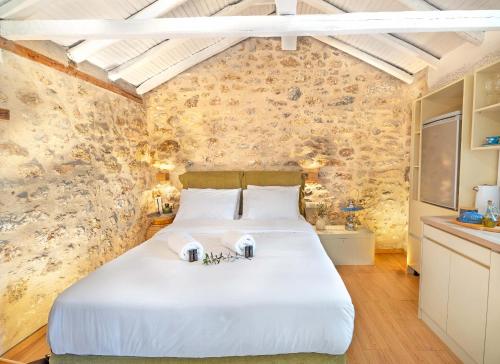 a bedroom with a large white bed in a room at Melias Olive Retreat in Kelefá