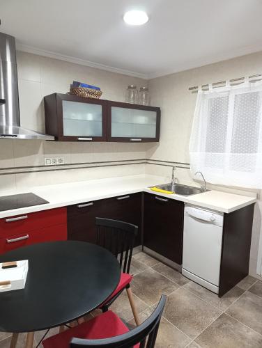 a kitchen with a table and a sink and a table and chairs at Aroca in Elda