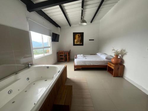 a large bathroom with a tub and a bed at Hotel Cerro Bravo in Fredonia