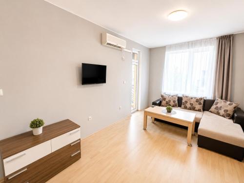 a living room with a couch and a table at Sunny Day 3 - Pool and Chill in Sunny Beach