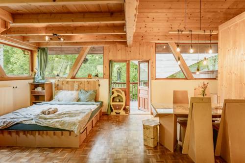 a bedroom in a wooden house with a bed and a desk at ECO-CHALET Bel Oiseau - Saint-Ursanne in Saint-Ursanne