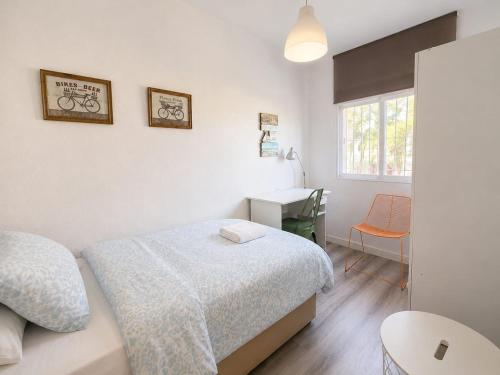 a white bedroom with a bed and a desk at Centrico apartamento en Leganes in Leganés