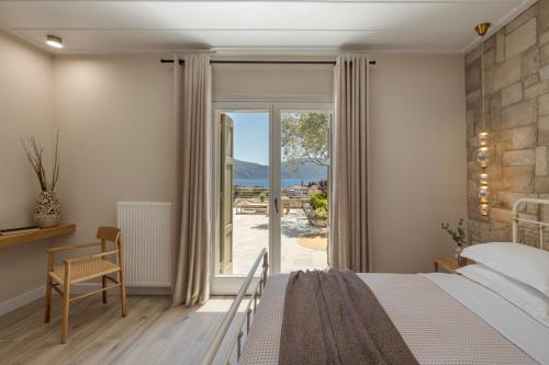 a bedroom with a bed and a sliding glass door at Fiscardo View Villas in Fiskardo
