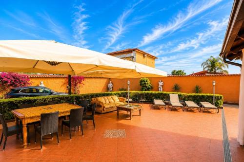 a patio with a table and chairs and an umbrella at B&b Villa Romano in Salerno