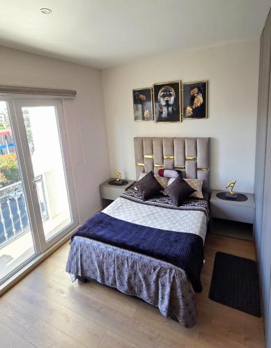 a bedroom with a bed and a large window at TORREMIA apartamentos de lujo in Cochabamba