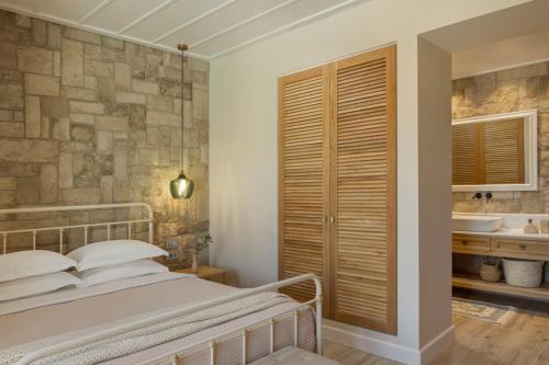a bedroom with a bed and a bathroom with a sink at Fiscardo View Villas in Fiskardo
