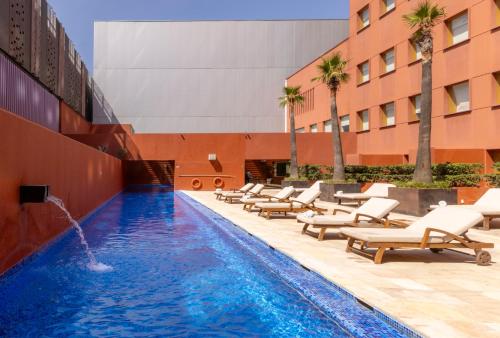 a swimming pool with lounge chairs and a hotel at Barceló Monterrey Valle in Monterrey