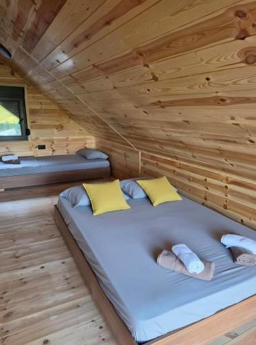 a bed in a room with a wooden ceiling at Stone Throne Retreat in Drušići