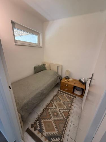 a small bedroom with a bed and a small window at Hegylakó vendégház in Balatonkenese