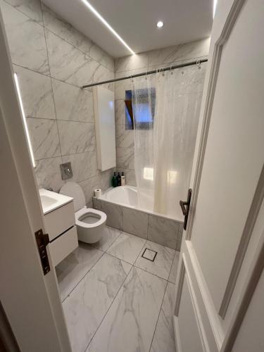 a bathroom with a toilet and a tub and a sink at Horizon 3 Villa in Amman