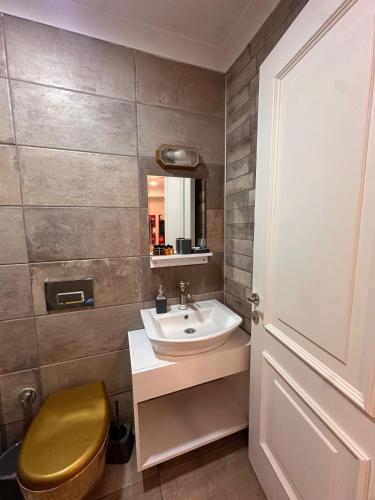 a bathroom with a sink and a toilet and a mirror at Lotus 4 Mevsim Otel in Ayvalık