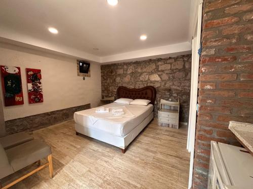 a bedroom with a bed and a brick wall at Lotus 4 Mevsim Otel in Ayvalık
