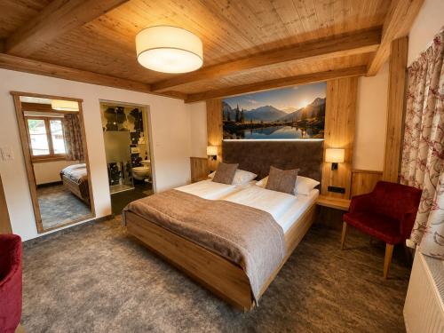 a bedroom with a bed and a large painting on the wall at Hotel Bechlwirt in Kirchberg in Tirol