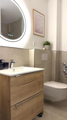 a bathroom with a sink and a toilet and a mirror at Nord Loft in Langeoog