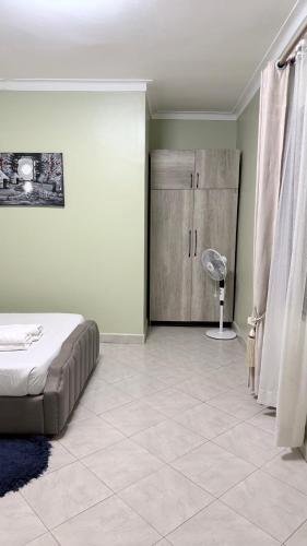 a bedroom with a bed and a closet with a fan at Supreme Apartments in Kansiri