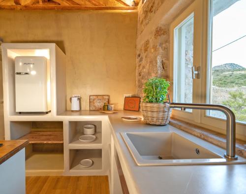 a kitchen with a sink and a window at Melias Olive Retreat in Kelefá