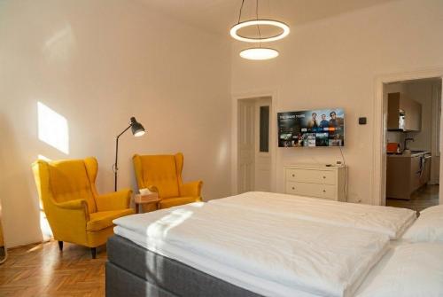 a bedroom with two yellow chairs and a bed at Villa Jahn in Baden