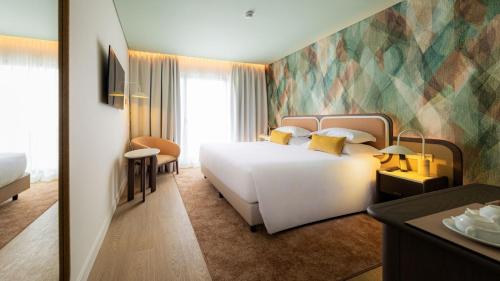 a bedroom with a large white bed in a room at Sao Miguel Park Hotel in Ponta Delgada