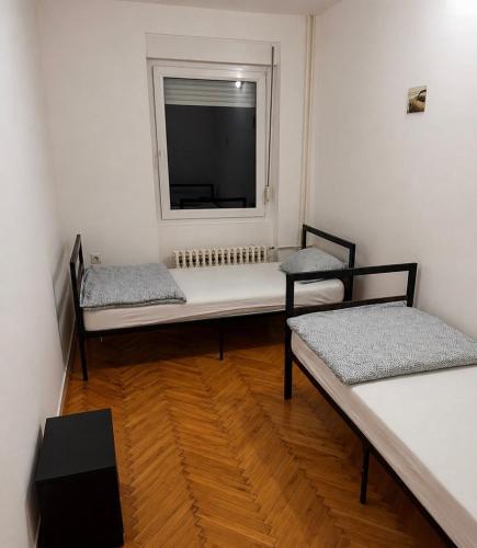a room with two beds and a window at Apartman City With 3 Bedooms And Free Parking in Negotin